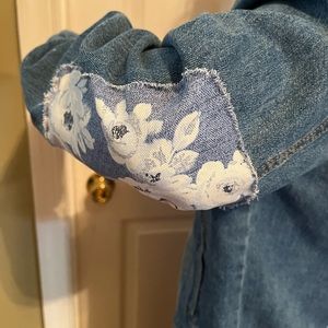 Size 0/2 custom Jean jacket with floral back panel and floral elbow patches.